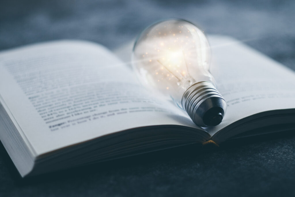 glowing lightbulb on open book