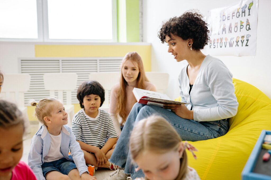 Teacher reading a book to a group of children